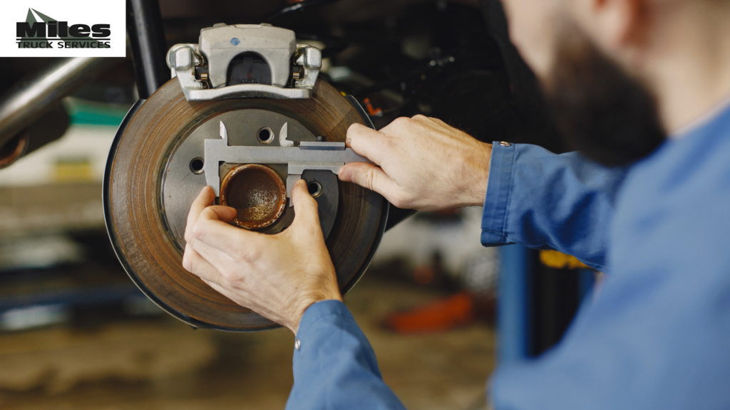 Technician inspecting a semi truck brake system at Miles Truck Services in Elkhart, Indiana
